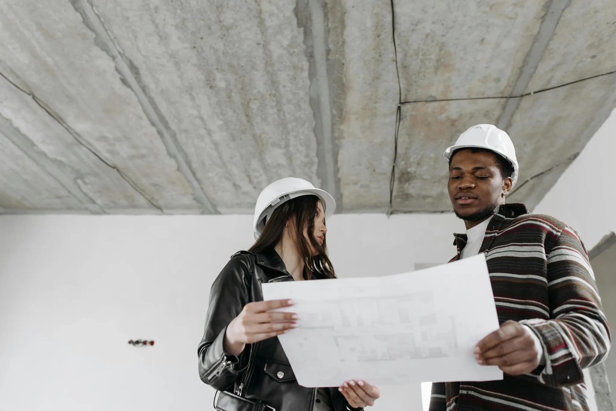 Two Central Developments construction workers reviewing a new development building plan on site.
