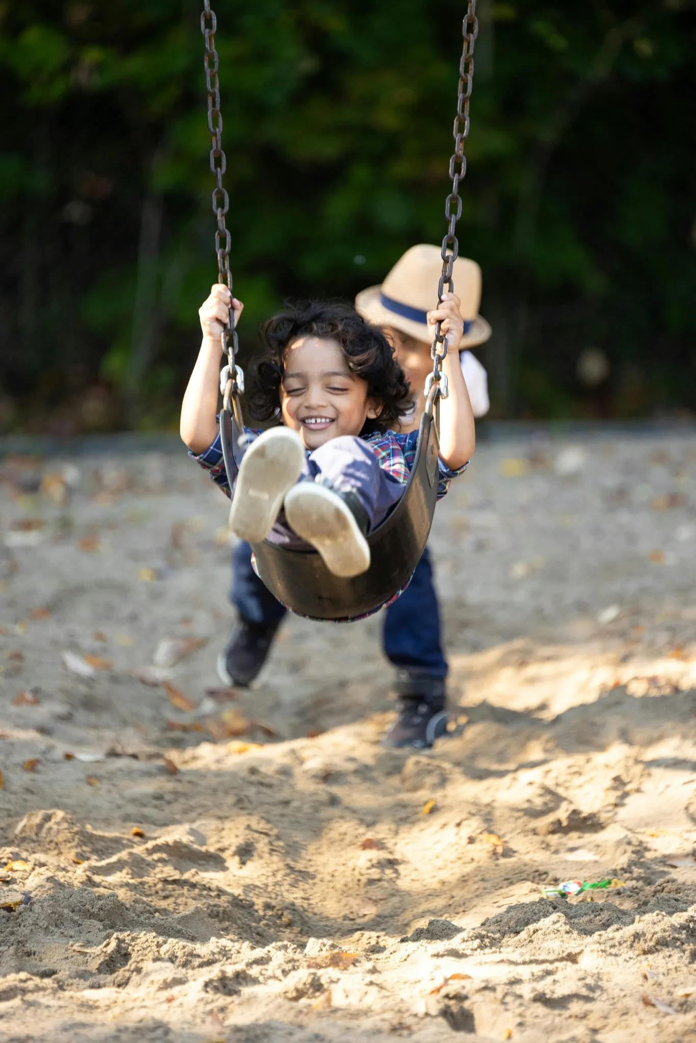 Two young boys playing on the swings at a Central Developments property play area.