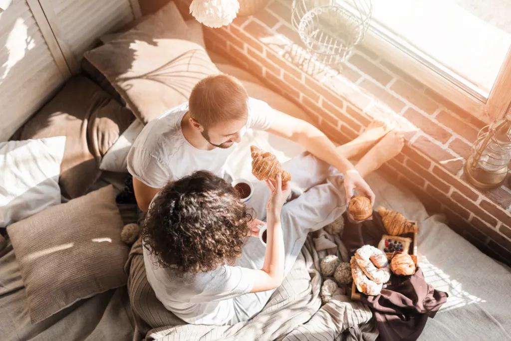 A young couple enjoying morning pastries in a comfortable Central Developments property.