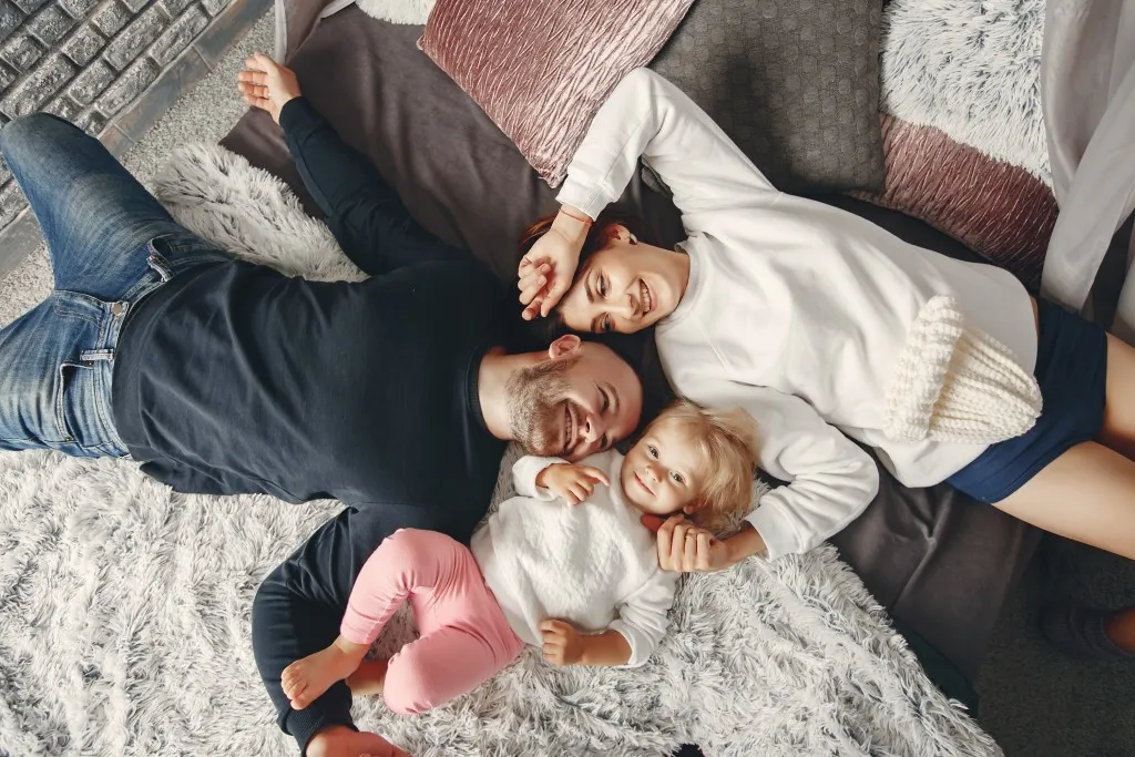 A young family bonding on a comfortable couch in their Central Developments home.