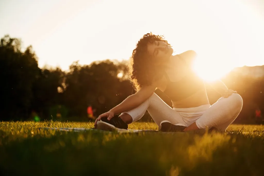 A young female stretching in the morning on lush Central Developments property lawns.
